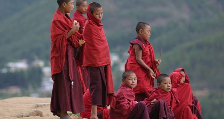 Eine Gruppe von Kindern in roten Gewändern, die auf eine malerische Landschaft blicken.