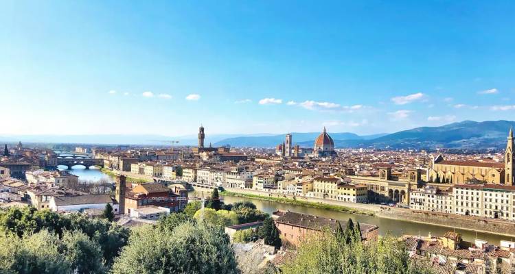 Panoramic view of Florence with the river and historic buildings.