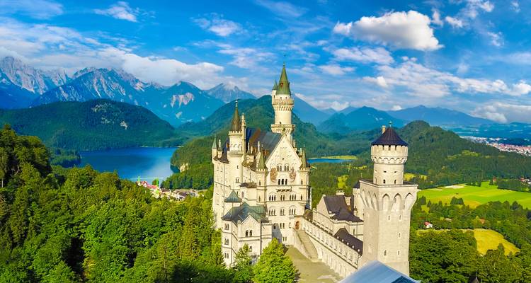 Neuschwanstein Castle with mountains and lake.