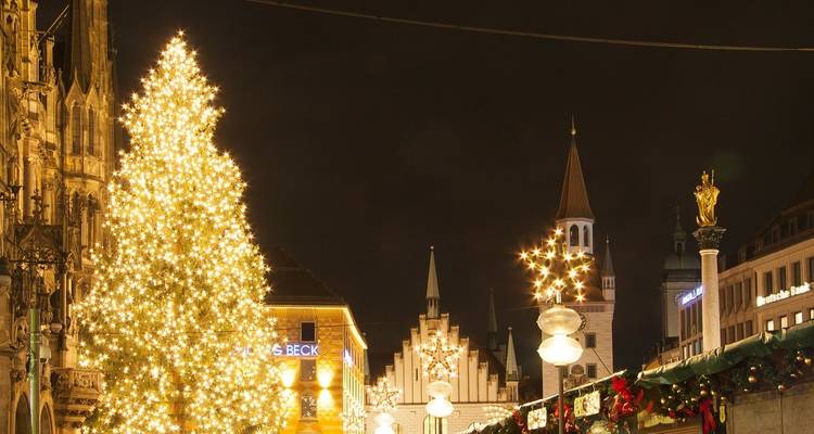 Weihnachtsschmuck in einer europäischen Stadt mit einer hoch aufragenden Kirche im Hintergrund.