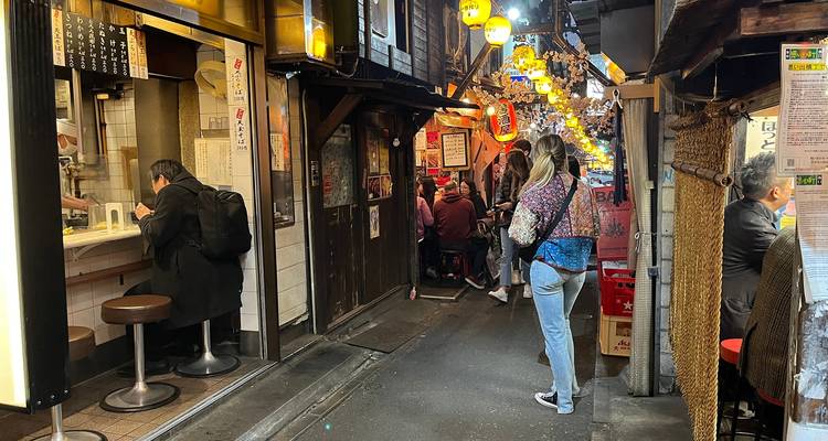Menschen, die ein belebtes Straßenessen-Viertel genießen, das mit Laternen geschmückt ist.