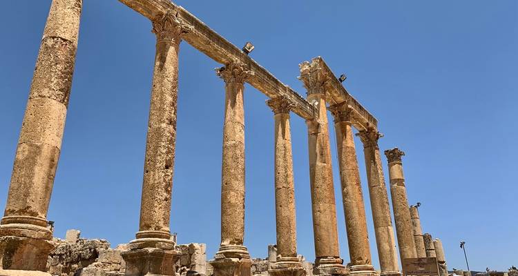 Ruines de colonnes antiques sous un ciel bleu dégagé.