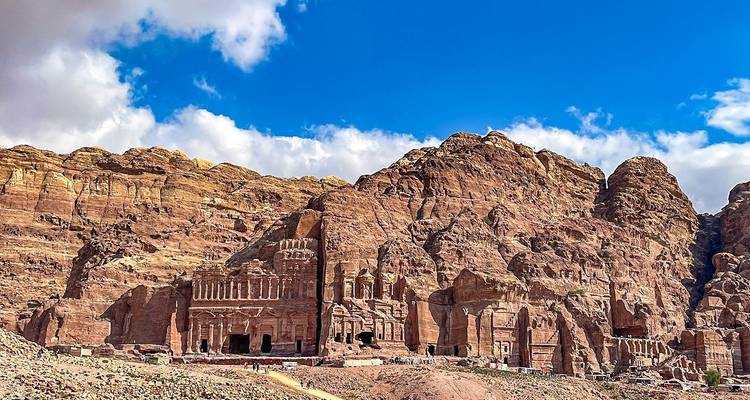 Façades taillées dans la roche à Pétra avec un arrière-plan montagneux.
