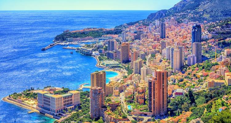 Vue aérienne lumineuse de la côte de Monaco et de son horizon urbain avec ses immeubles de grande hauteur se détachant sur la mer d'un bleu profond.