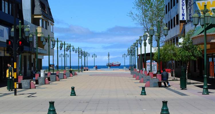 Rue menant à un navire avec des gens et des lampadaires.