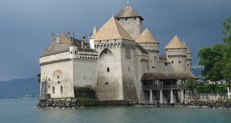 Castillo construido sobre un lago con acantilados escarpados.