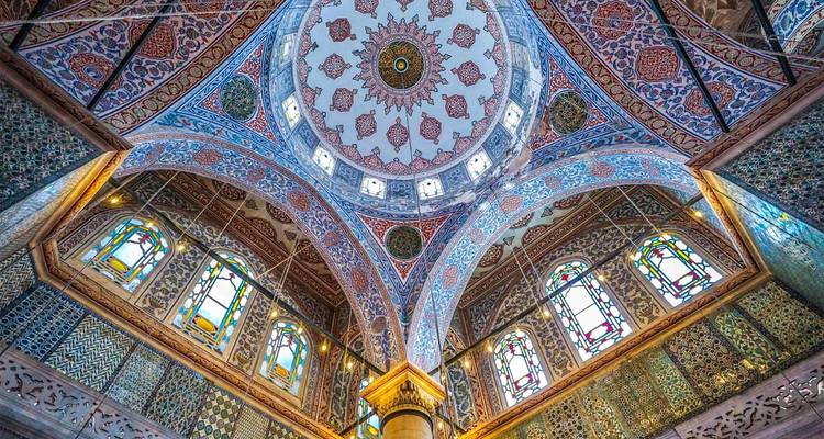 Sierlijke interieur met een versierd plafond en glas-in-lood.