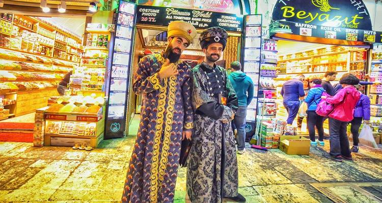 Twee mannen in traditionele Turkse kostuums bij de ingang van de markt.