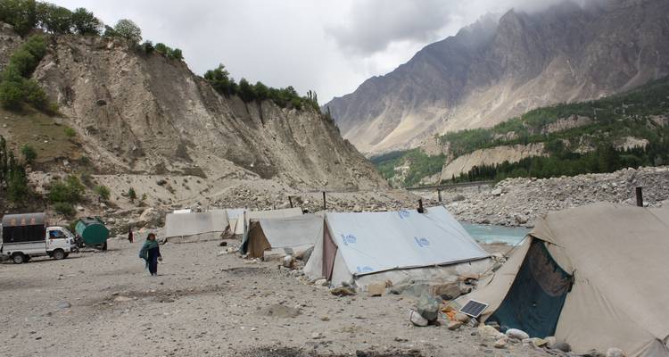 Lagerplatz am Fluss mit Berglandschaft.