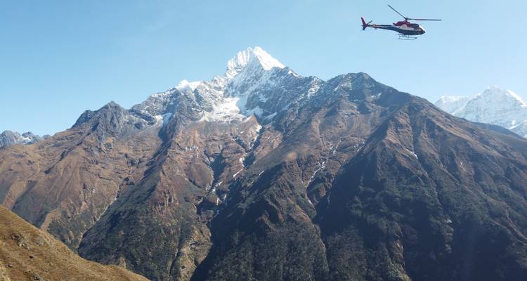 Un hélicoptère volant au-dessus d'un paysage montagneux spectaculaire.