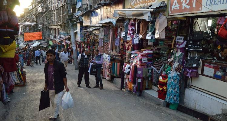 Belebte Marktstraße mit Geschäften und Menschen.