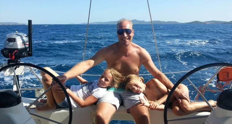 Man en twee kinderen ontspannen op een jacht op zee.