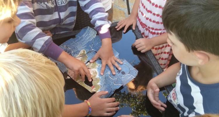 Kinderen die een puzzel in elkaar zetten op een tafel.