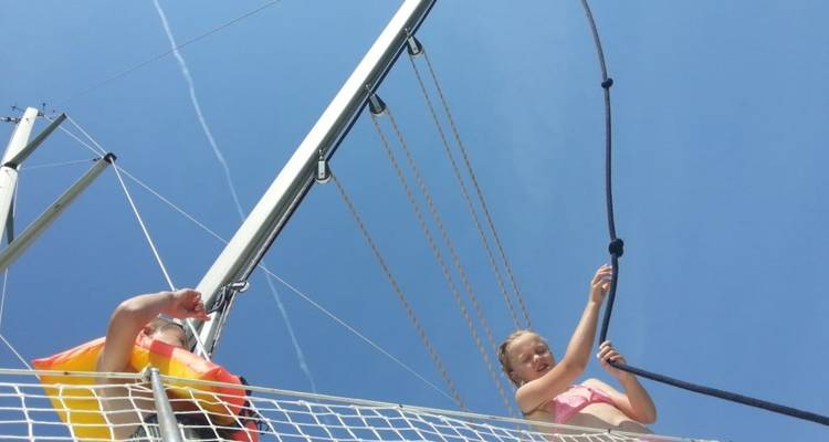 Kinderen die spelen bij de mast van een boot.