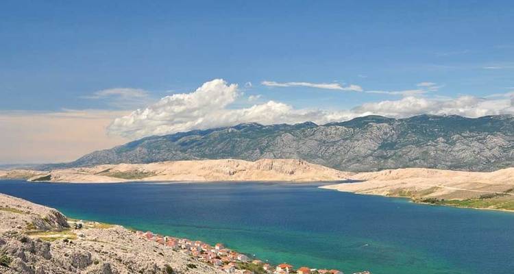 Vista panorámica de un paisaje costero con cielos despejados y aguas azules.