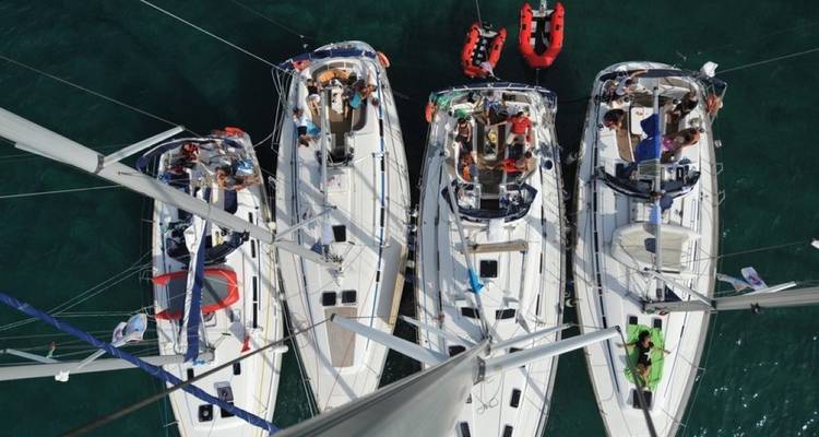 Vogelperspektive von drei Segelbooten mit Menschen an Bord.