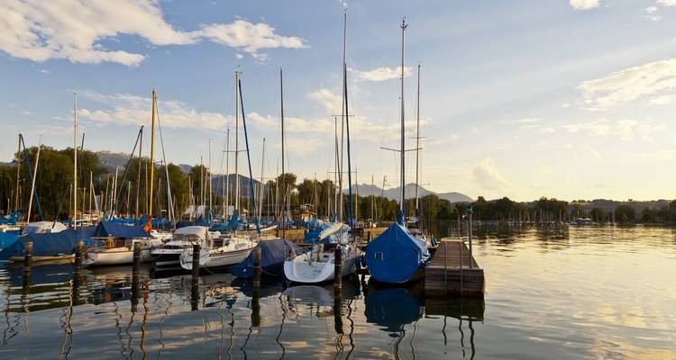 Zeilboten aangemeerd in een jachthaven met bergen in de verte.