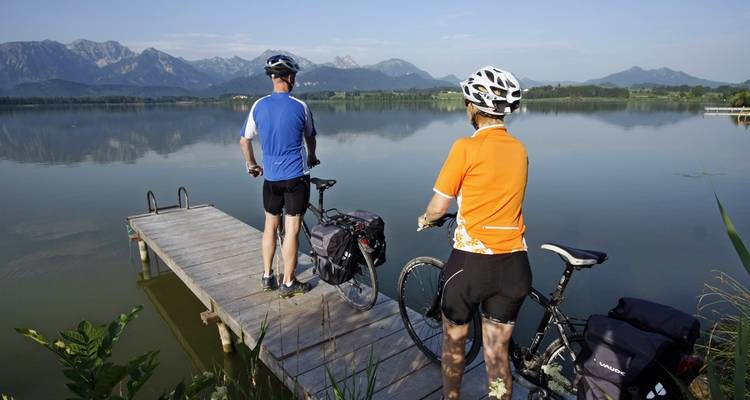Fietsers op een houten steiger bij een serene meer.