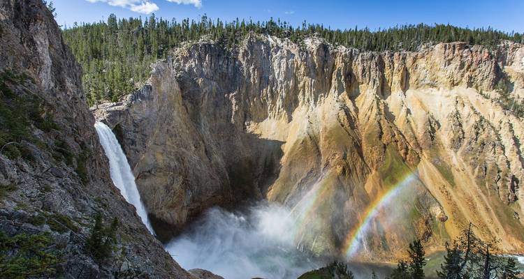 Wasserfall mit einem Regenbogen über seinem Nebel.