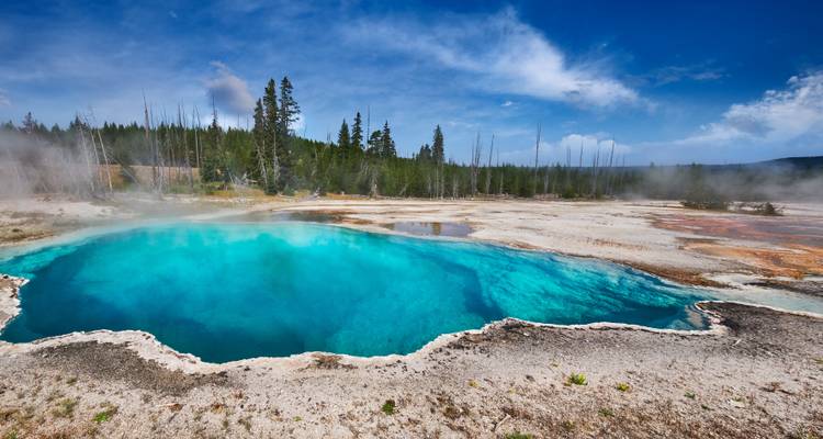 Lebhafter türkisfarbener Geothermalpool mit aufsteigendem Dampf.