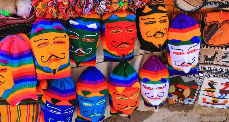 Bunte gestrickte Masken hängen zur Schau.