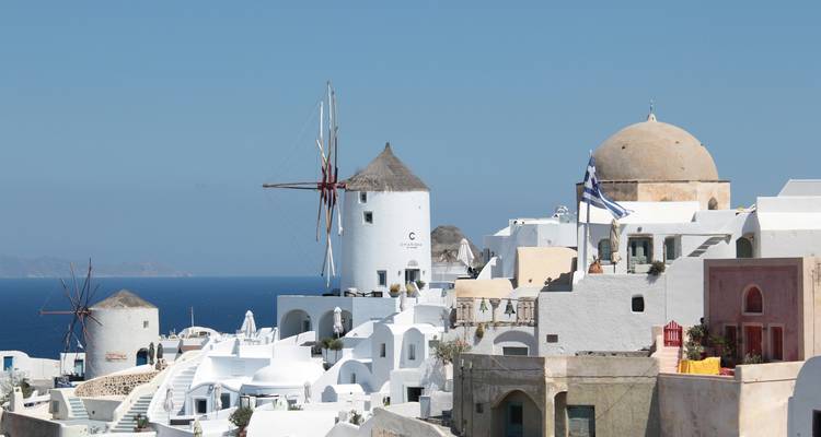 Bâtiments blancs et bleus à Santorin avec des moulins à vent.