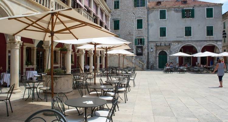 Terrasse de restaurant en plein air sur une place historique.