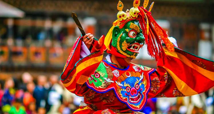 Een danser in kleurrijke traditionele Bhutaanse klederdracht.
