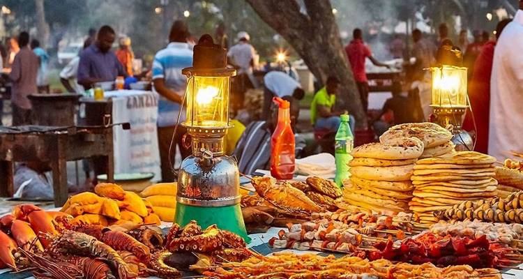 Outdoor food market with various dishes displayed.