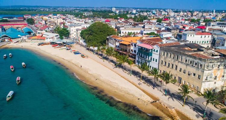 Aerial view of a coastal city with beach and boats.