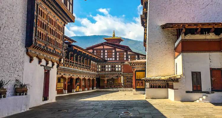 Innenhof eines traditionellen bhutanischen Dzongs mit kunstvoller Holzschnitzerei.