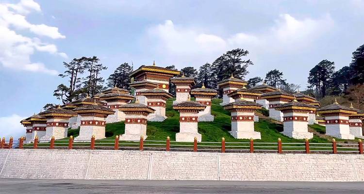 Ein Hügel mit mehreren Chörten, umgeben von Bäumen.