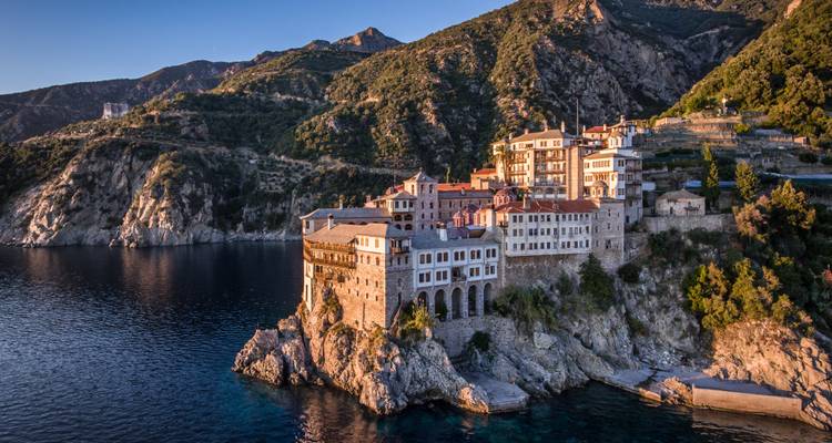 Un monastère de pierre spectaculaire s'accroche aux falaises côtières escarpées au-dessus des eaux bleu profond du mont Athos.