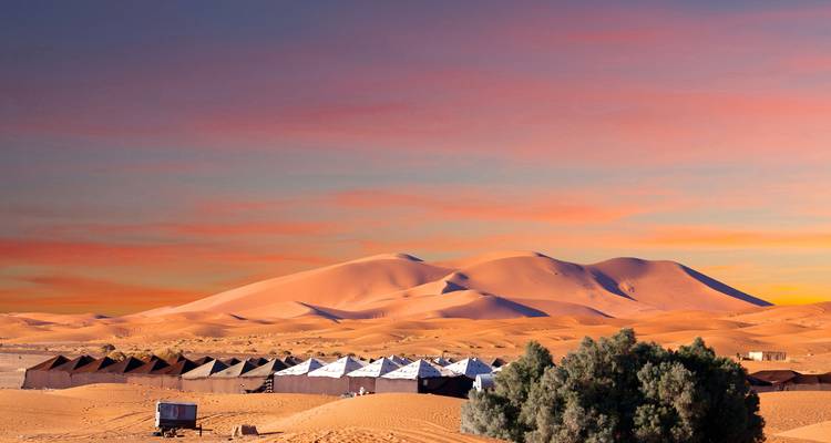 Malerische Wüstenlandschaft mit großen Sanddünen bei Sonnenuntergang.