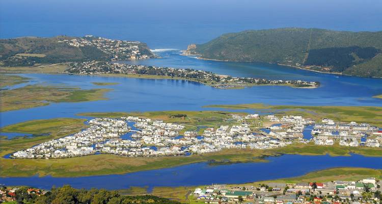 Aerial view of a coastal lagoon surrounded by lush landscapes.