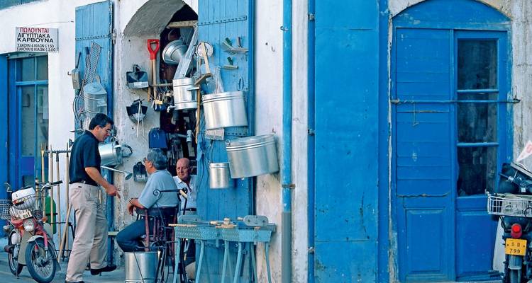 Straßenmarkt mit blauen Türen und lokalen Waren.