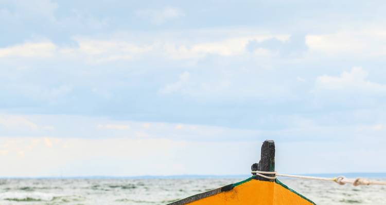 Teil eines kleinen Bootes gegen ein Gewässer.