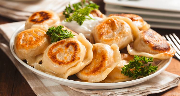 Teller mit gebratenen Teigtaschen, garniert mit Petersilie.