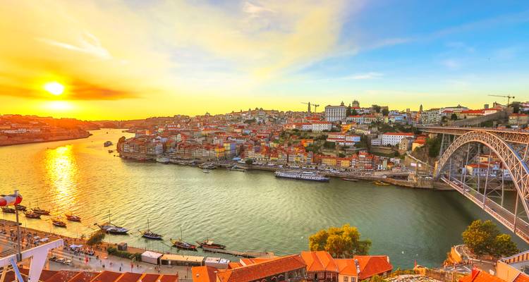 Coucher de soleil doré sur le Douro, la skyline colorée de Porto et le pont Dom Luís I.