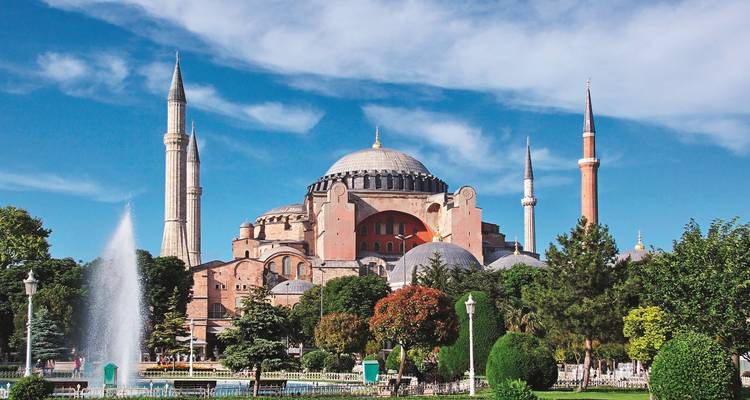 Hagia Sophia mit klarem blauem Himmel und üppiger Umgebung.