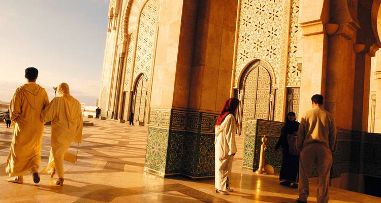 Mensen die lopen in de buurt van Marokkaanse architectuur.