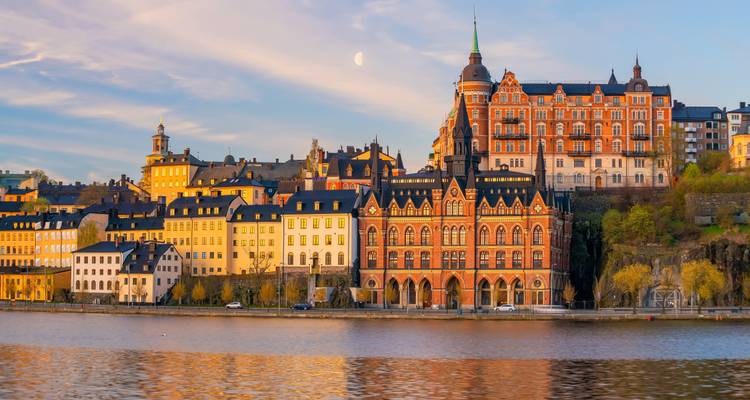 Das Hafenviertel von Stockholm erleuchtet im sanften Abendlicht mit dem aufgehenden Mond über historischen Fassaden.