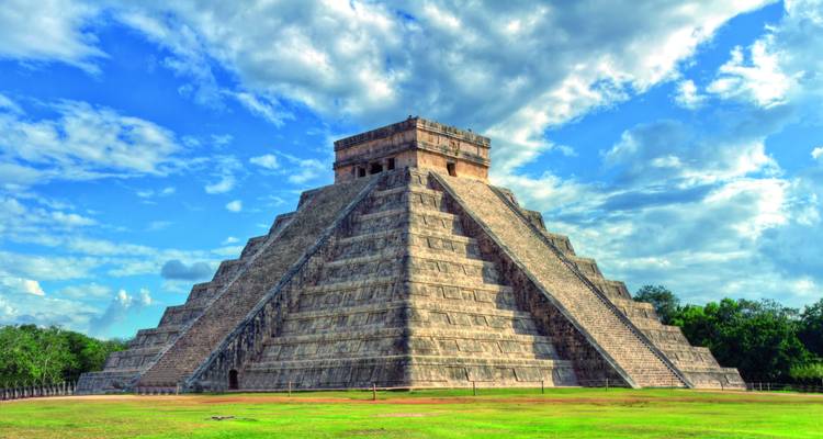 Die El Castillo Pyramide von Chichen Itza erhebt sich majestätisch unter dramatischen Wolken und blauem Himmel