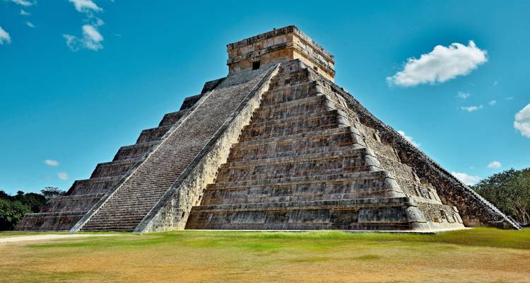 Pyramide von Chichen Itza vor blauem Himmel.