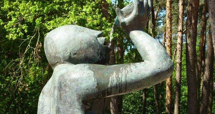 Bronze statue of a person drinking water.