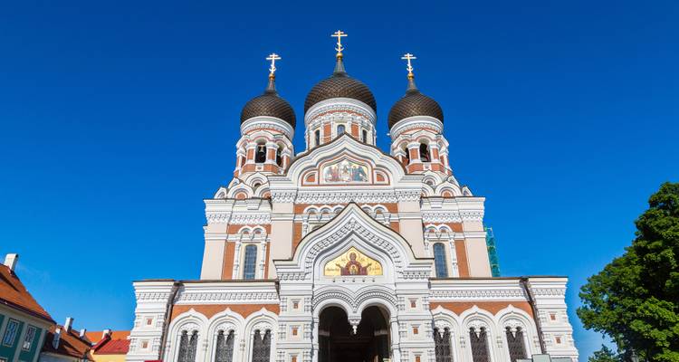 Frontfassade der Alexander-Newski-Kathedrale mit leuchtenden Kuppeln vor einem tiefblauen Himmel.