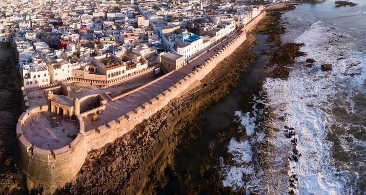 Vue panoramique aérienne des remparts fortifiés d'Essaouira et de la médina s'étendant le long du littoral atlantique accidenté.