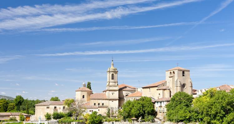 Skyline eines kleinen spanischen Dorfes mit Kirchtürmen unter gestreiftem blauem Himmel