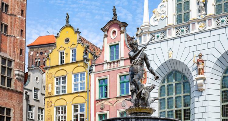 Primer plano de las fachadas históricas ornamentadas y la estatua de la Fuente de Neptuno en el Long Market de Gdansk.