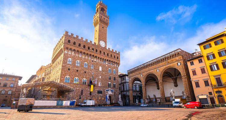 Der Palazzo Vecchio überragt eine offene Piazza unter einem strahlend blauen Morgenhimmel in Florenz.